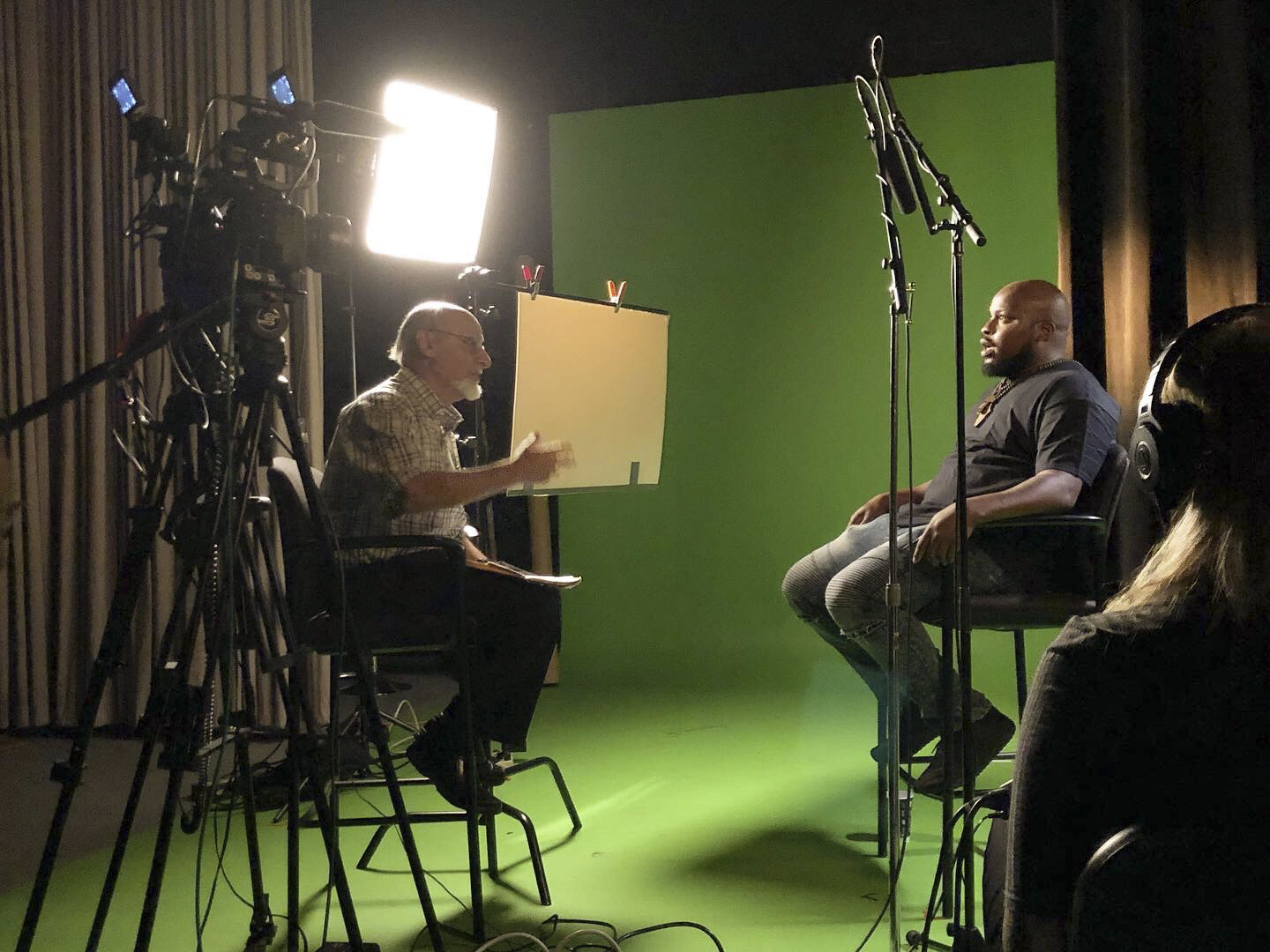 two people in a studio in front of green background