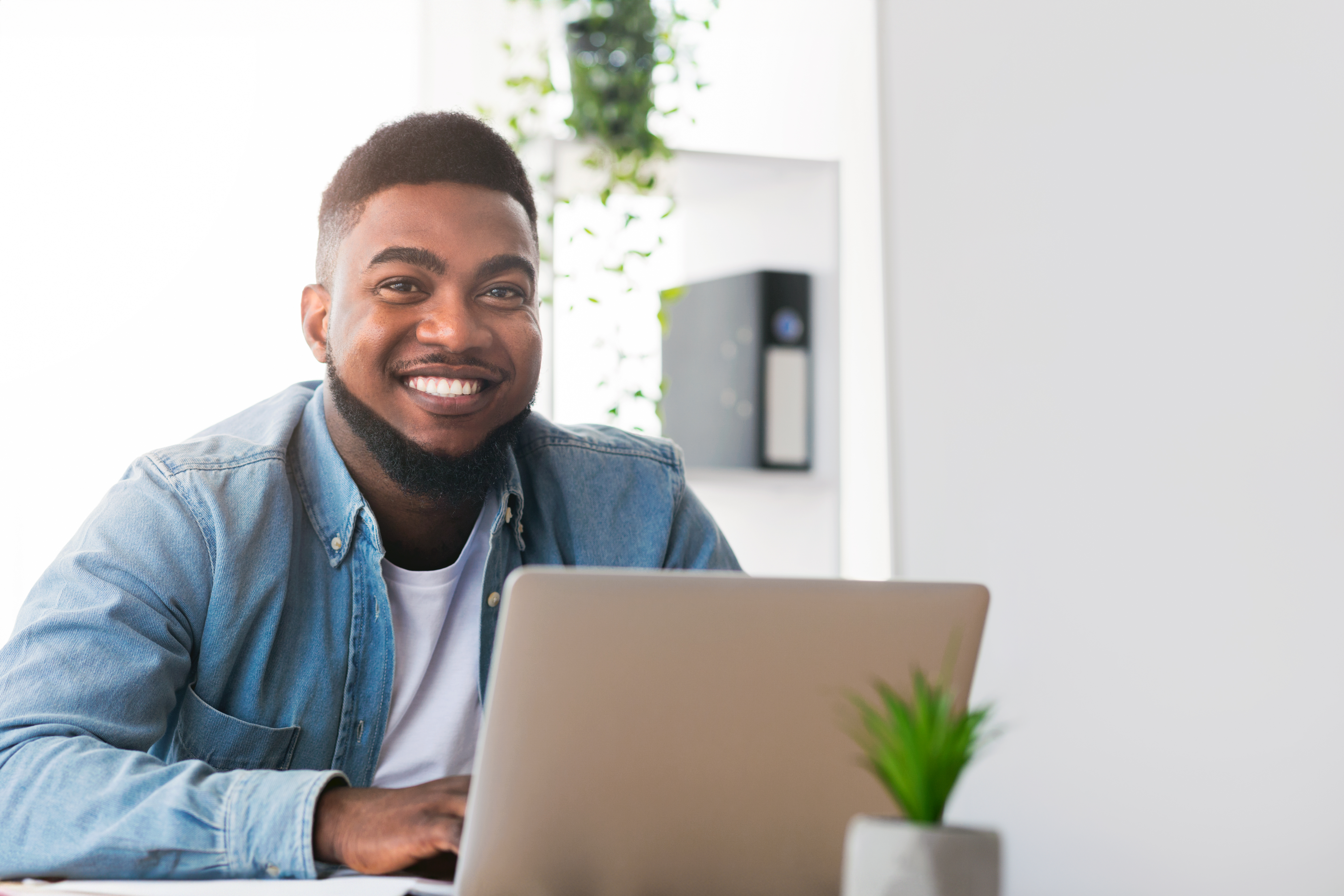 Young African American male at a laptop smiling