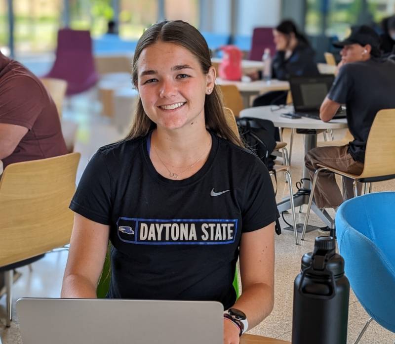 A students working on her laptop in the student center. 