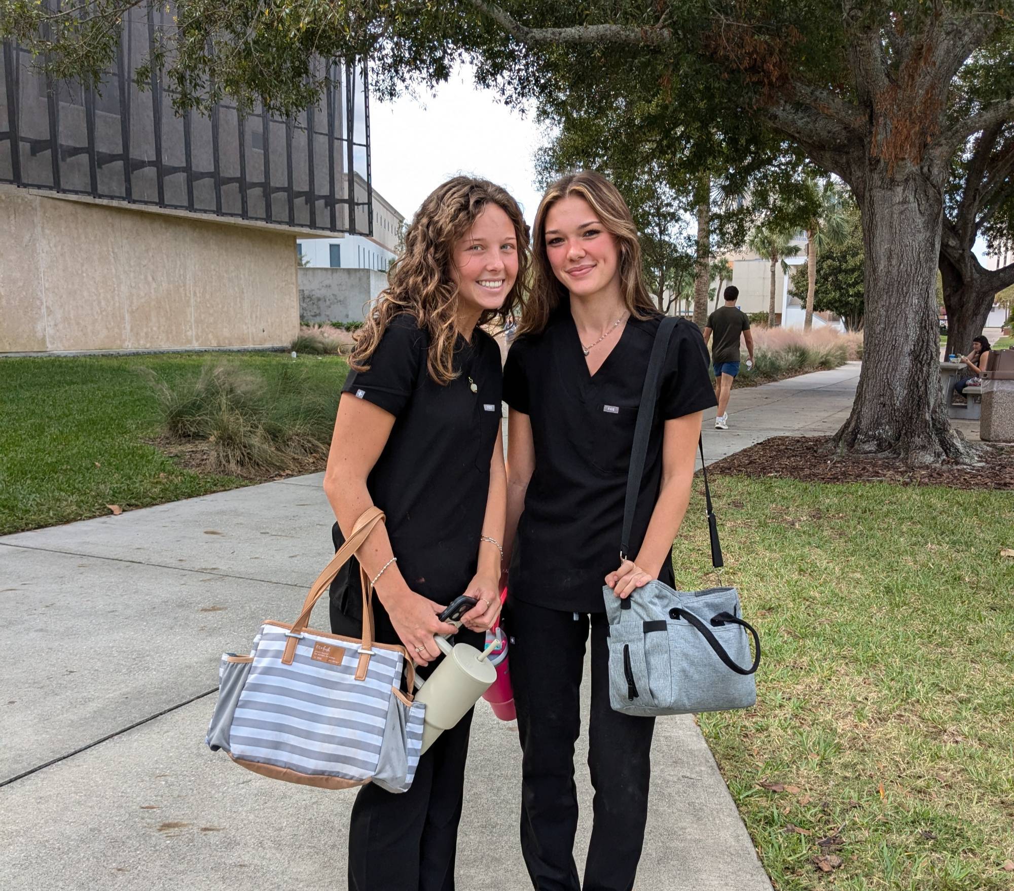 Two cosmetology students outside the Lemerand Student Center.