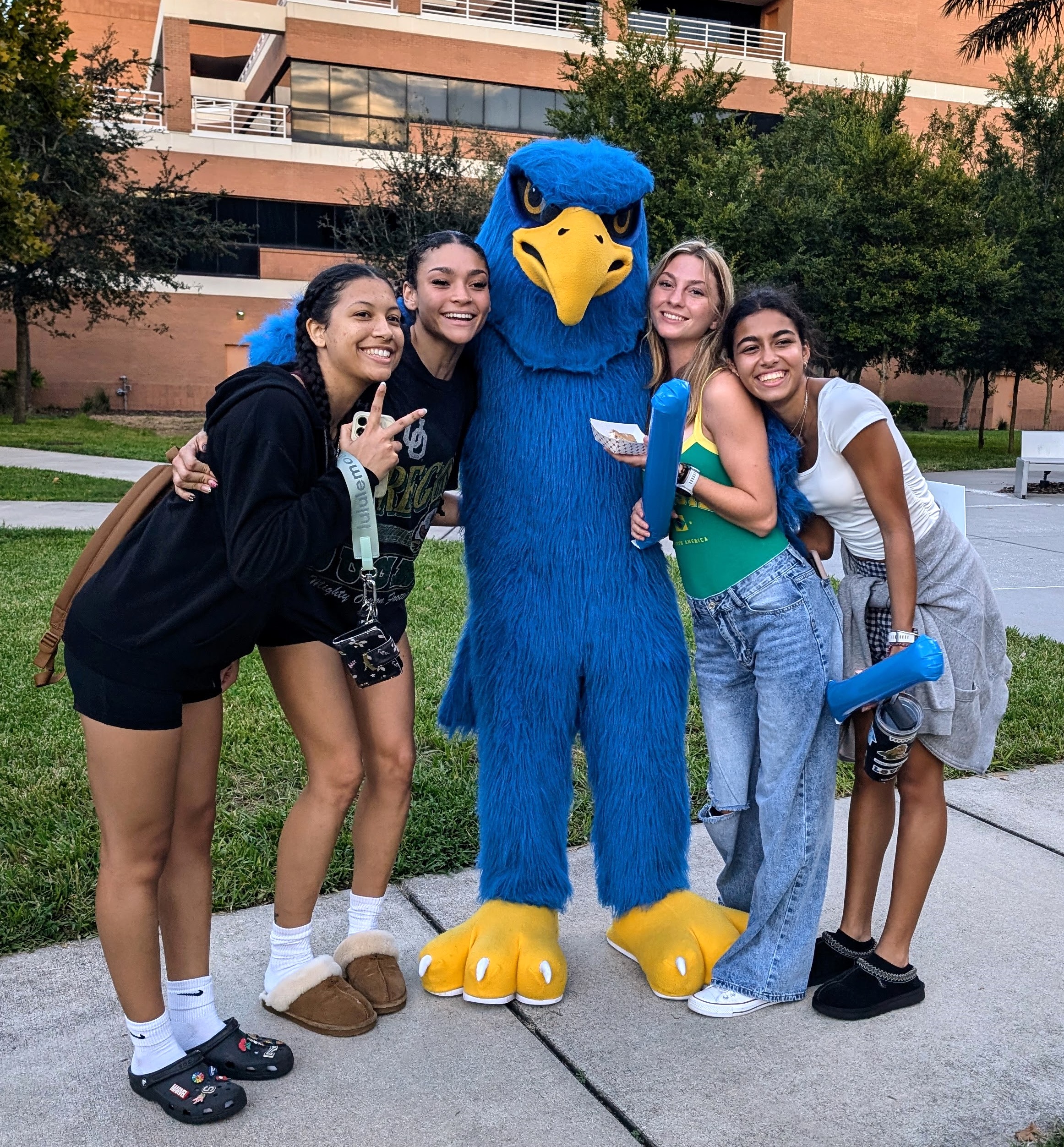 Four smling students gathered at the picinc table enjoying the beautiful day 