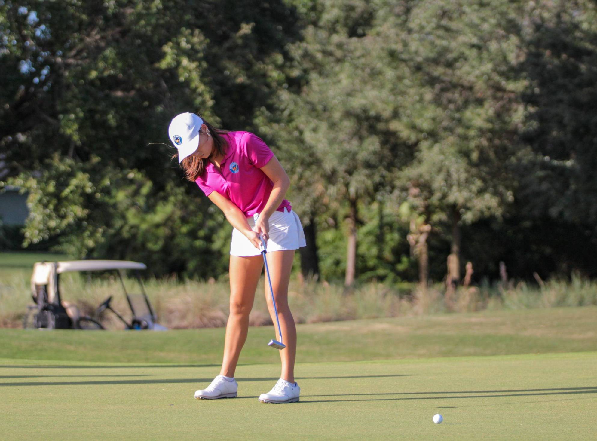 Women's golfer putting on the green. 