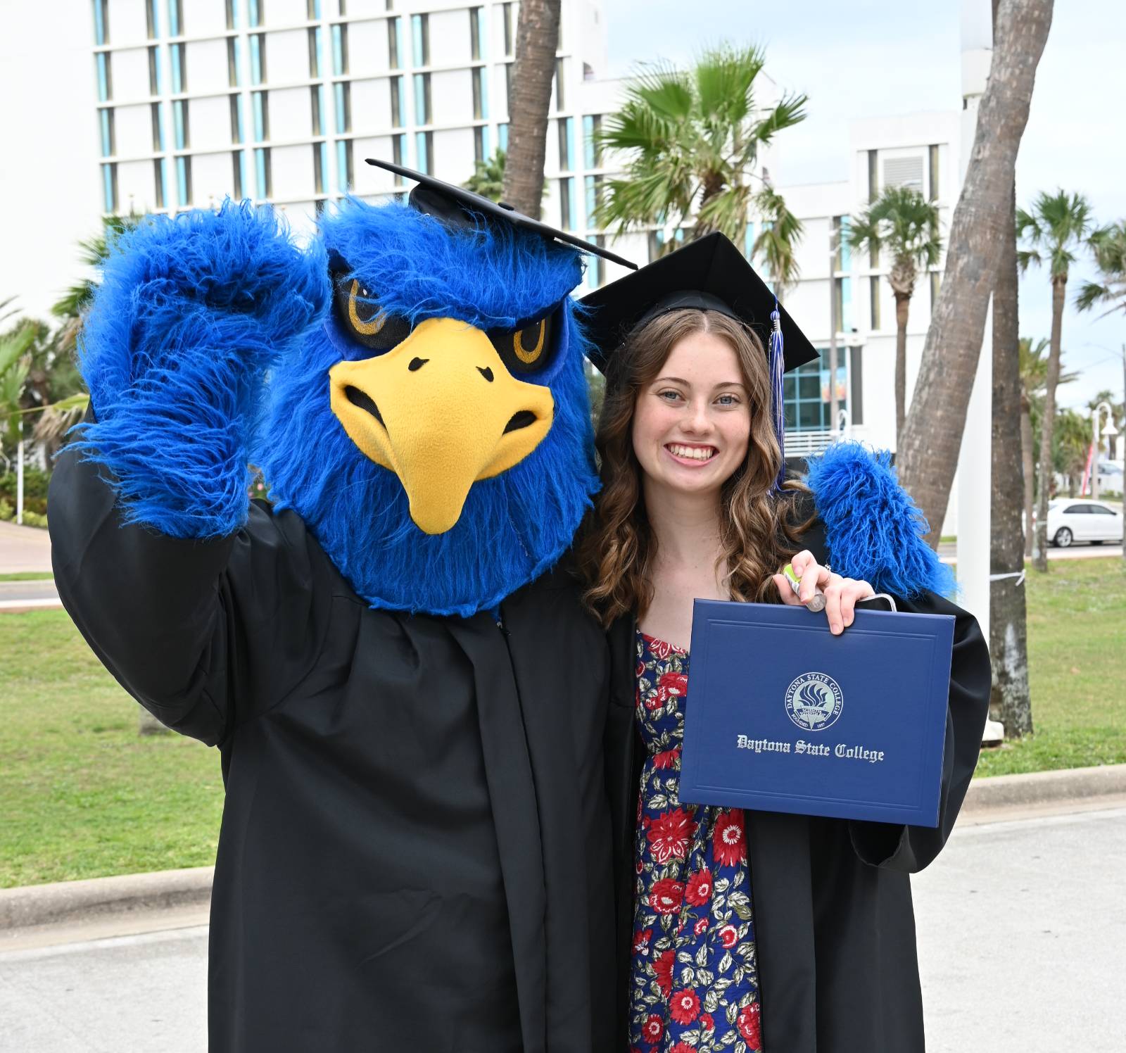 A new graduate and Freddie Falcon posing with a DSC degree. 