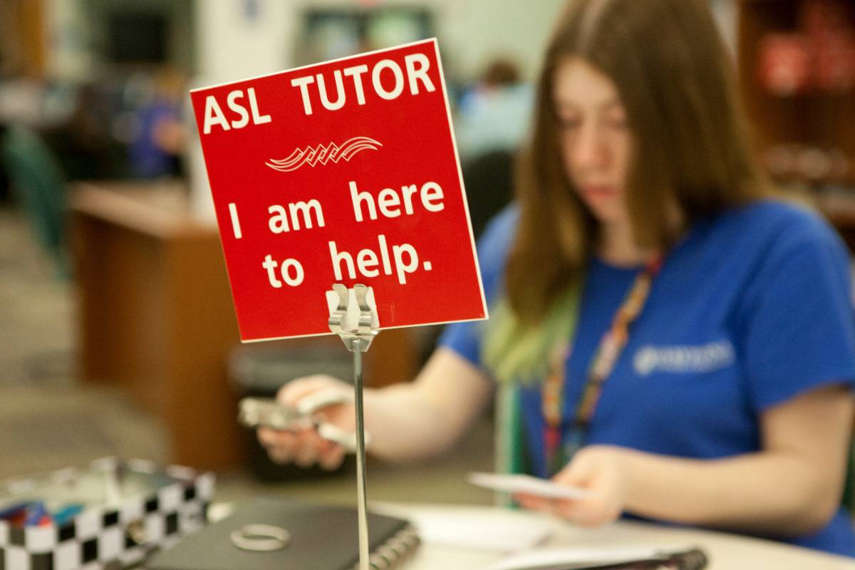 student American Sign Language tutor at a desk