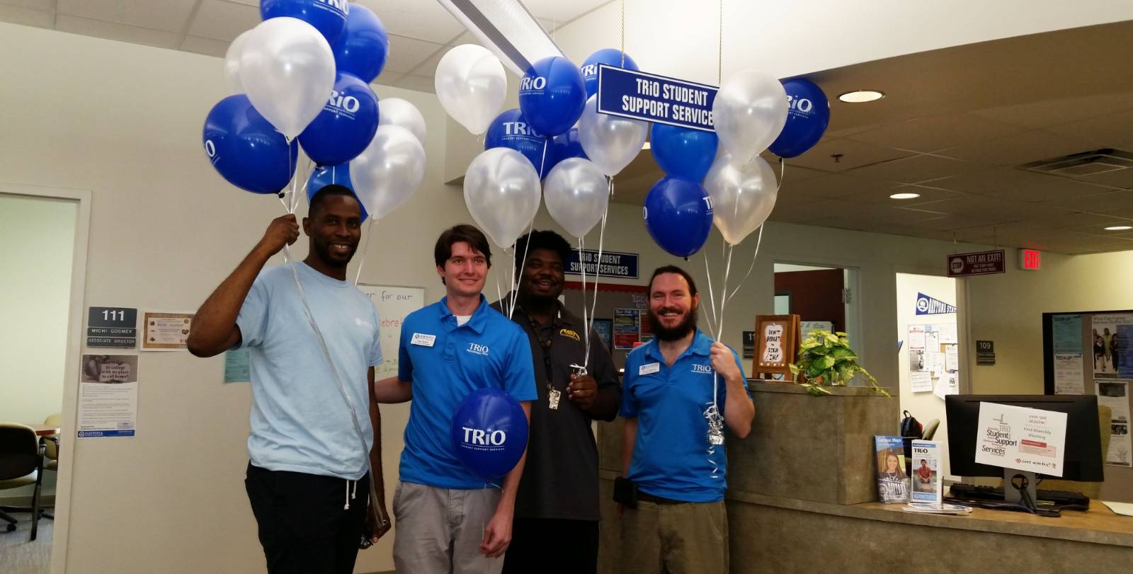 trio tutors at the front desk with balloons