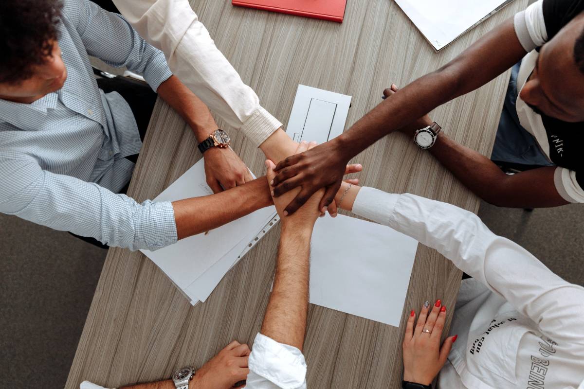 five business people in a huddle over a table