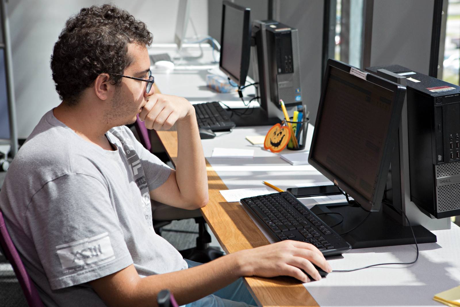 student looking thoughtful at a computer